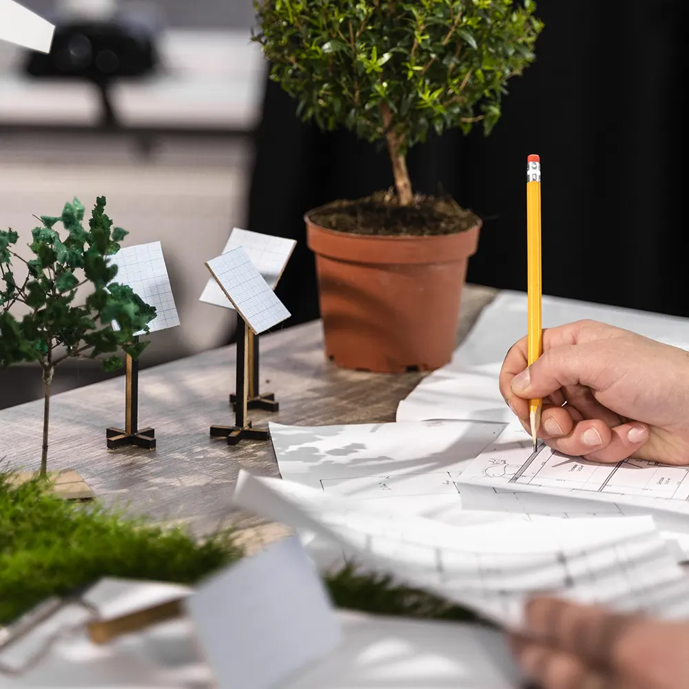 persona sentada en un escritorio con muchas plantas y papeles, planificando implementar la nueva ley rep