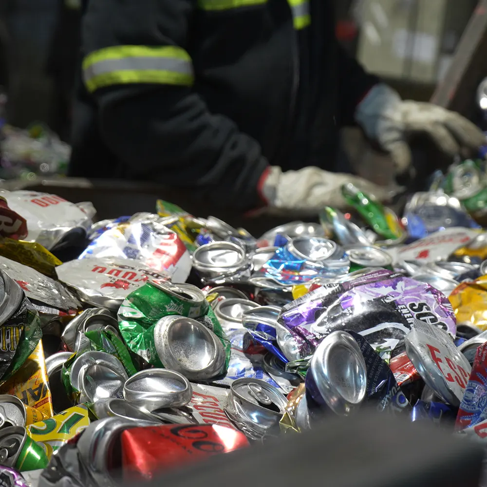 trabajador de Norte Verde revisando las latas en banda transportadora